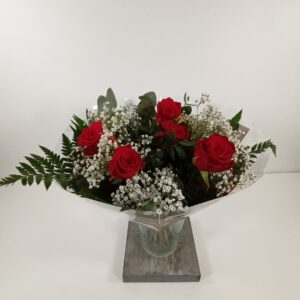 Kimppu kotimaisista ruusuista ja harsokukasta.